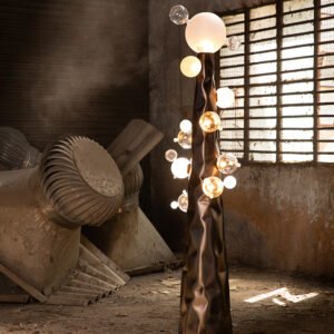 Sculptural floor lamp with a stainless steel crumbled base and blown glass balls resembling molecules in a factory setting.