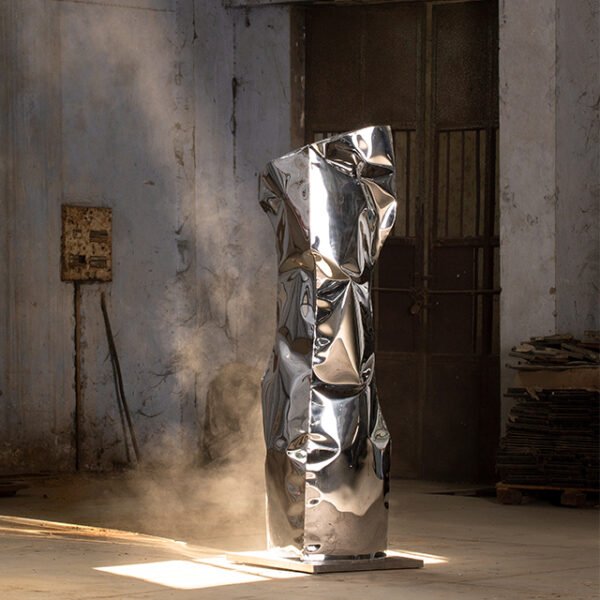 Stainless steel floor sculpture resembling an ancient monolith