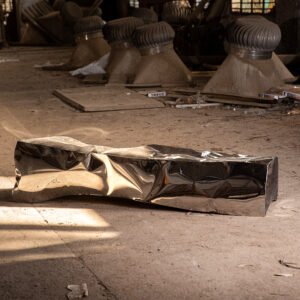 Sculptural bench in stainless steel mirror finish resembling an ancient monolith