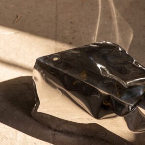 Detail of sculptural bench showing stainless steel mirror finish and reflections