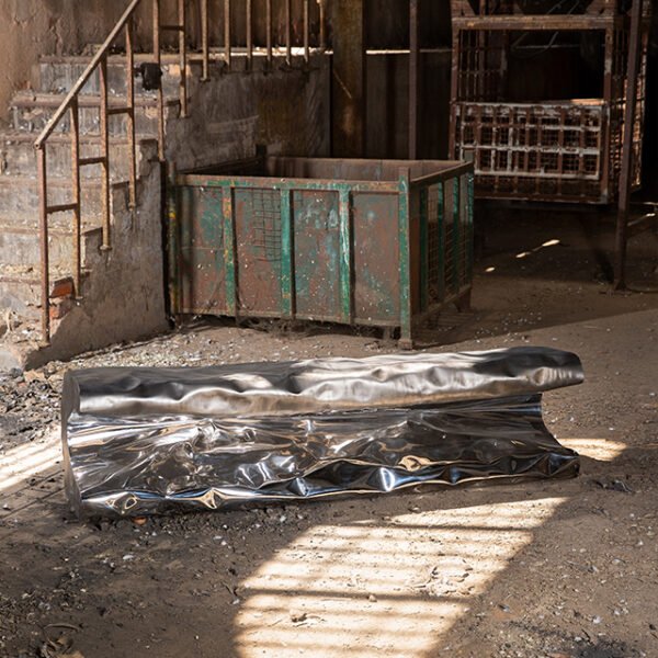 Metal bench in organic chape with sculptural texture.