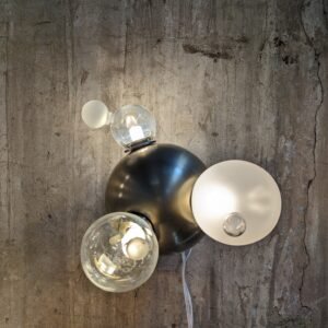 Closeup of the sculptural light installation featuring one piece with blown glass and stainless steel ball.