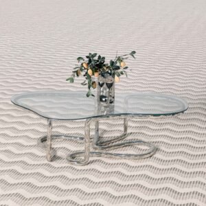 Lasso Coffee Table with rope-inspired polished steel base and glass surface on patterned floor