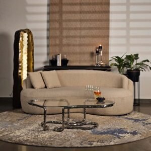 Lasso Coffee Table with polished stainless steel base and glass top, styled alongside Sigil Tower Lamp