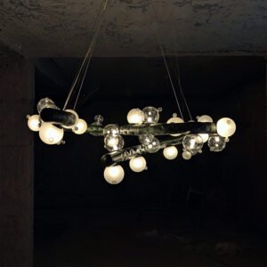 Molecule Lasso Light illuminating a modern living room – sculptural chandelier in stainless steel and glass