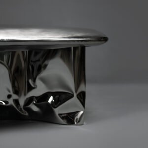 Side detail of Pebble Coffee Table with polished stainless steel base and antique top